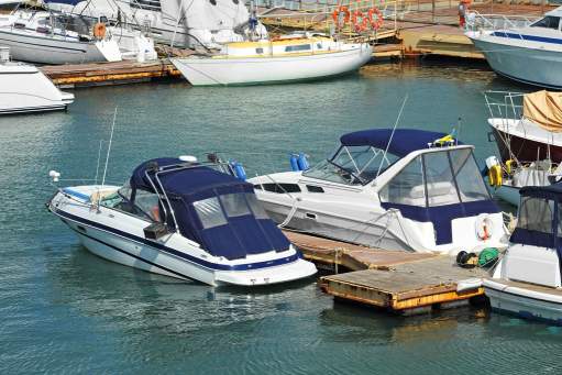 Multiple blue/white boats on blue water near brown dock